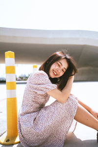 Portrait of a smiling young woman sitting outdoors