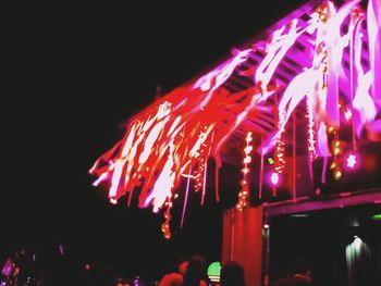 Low angle view of illuminated christmas lights at night