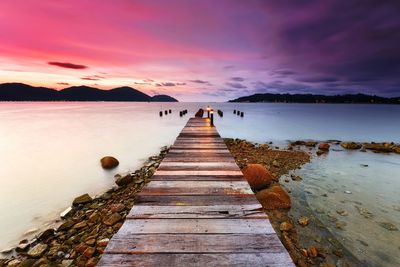 Pier over sea at sunset