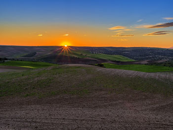 Scenic view of field against sky during sunset