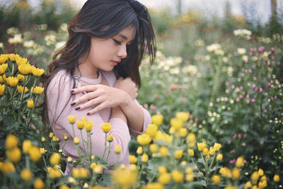 Close-up of young woman with yellow flowers