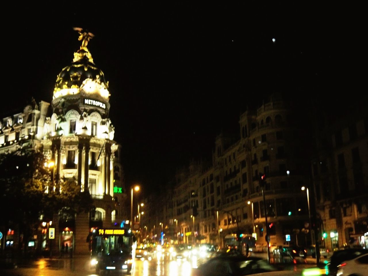 building exterior, architecture, illuminated, night, built structure, city, street, car, transportation, road, street light, city life, land vehicle, city street, travel destinations, sky, travel, incidental people, traffic, building