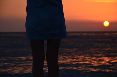 Wife standing on beach during sunset