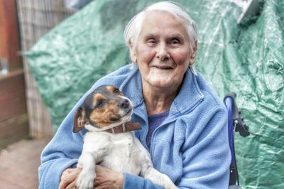 Portrait of senior woman holding pet dog