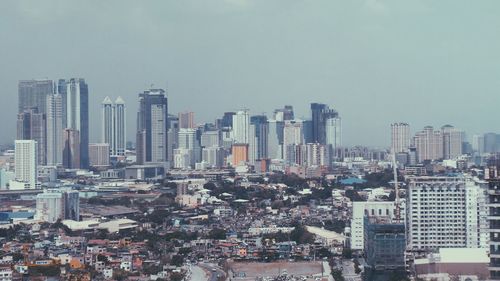 Aerial view of buildings in city against clear sky