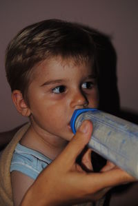 Cute baby boy drinking milk at home