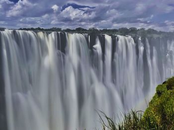 Scenic view of waterfall against sky