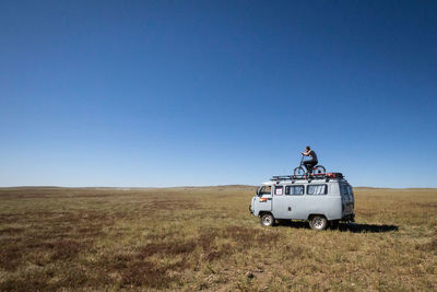 View of truck on field against clear blue sky