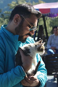 Man carrying cat outdoors