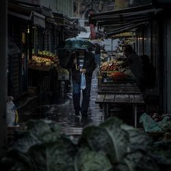 People standing at market stall in rainy season