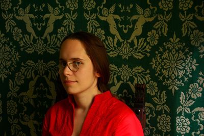 Portrait of beautiful young woman against wall