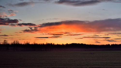 Scenic view of silhouette field against sky during sunset