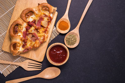 High angle view of pizza with wooden cutleries on table