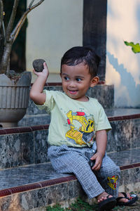 Portrait of cute boy sitting outdoors