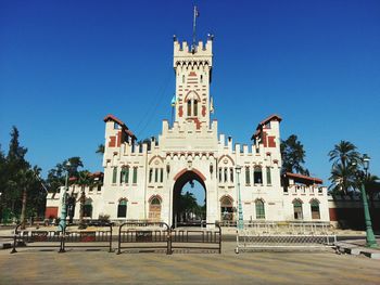 Low angle view of gate montaza palace against clear blue sky