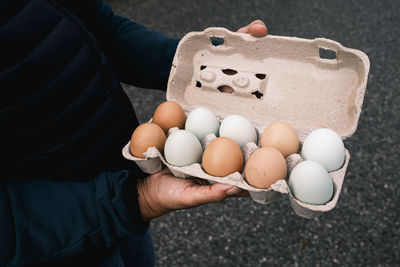 Woman holding tray with white and brown eggs