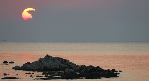 Scenic view of sea against clear sky at sunset