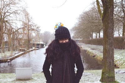 Woman standing on snow covered field during winter