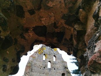 Low angle view of old building seen through cave