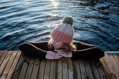 Woman leaning on a pier whilst in the water cold water swimming