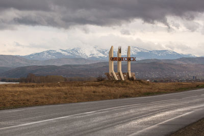 Scenic view of road by mountains against sky