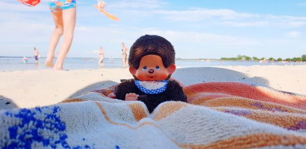 Full length of happy boy on beach against sky