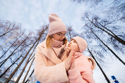 Mother and daughter happily embrace spring walk in the park sunny day