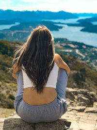 Woman in landscape looking at horizon mountains and lakes
