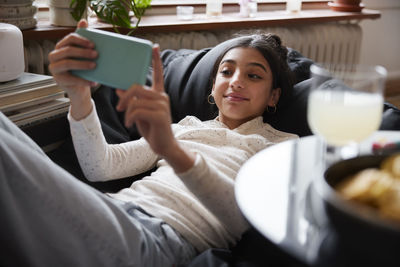 Girl lying on bean bag and taking selfie