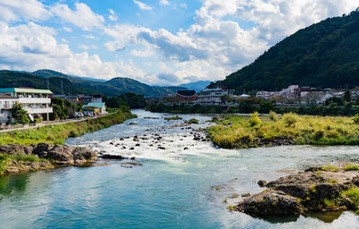 Scenic view of lake by buildings against sky