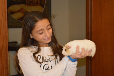 Smile girl holding hamster at home