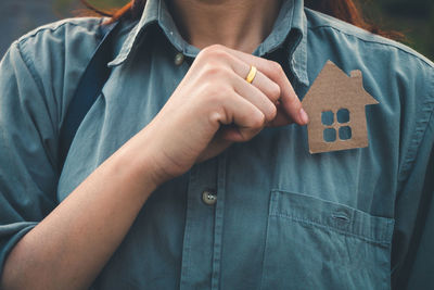Midsection of man holding hands standing against blue wall