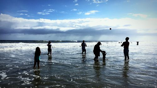 People at beach against sky