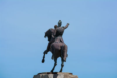 Low angle view of statue against clear blue sky