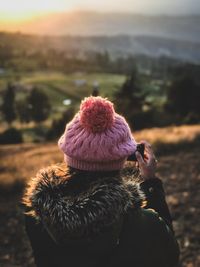 Rear view of woman photographing during winter