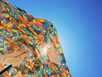 Low angle view of cross against clear blue sky