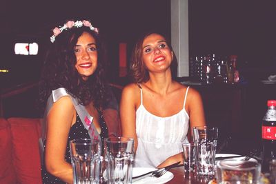 Female friends smiling while sitting at restaurant