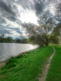 Scenic view of grassy field against cloudy sky