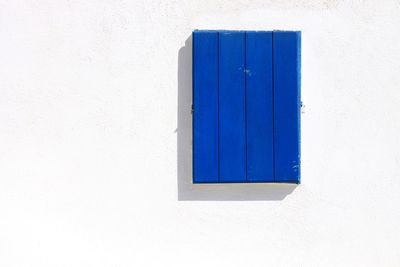 Close-up of blue window on white wall