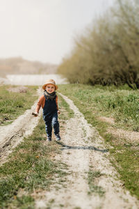 Full length of child running on a pathway in the country