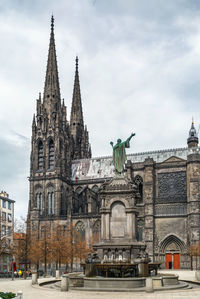 Statue of historic building against cloudy sky