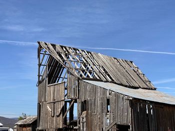 Low angle view of abandoned barn against sky