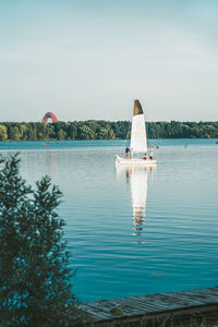 Rear view of woman in lake against sky