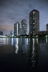 Reflection of illuminated buildings in city at night