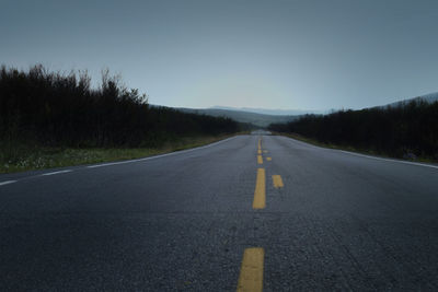 Surface level of empty road against clear sky