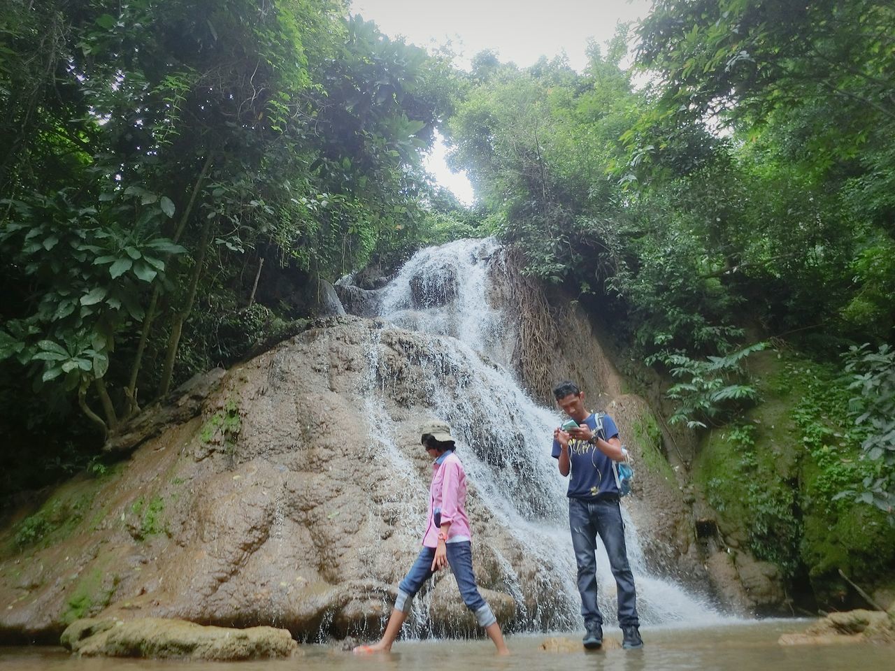 lifestyles, tree, leisure activity, full length, casual clothing, green color, forest, nature, rock - object, growth, backpack, plant, day, tourist, outdoors, beauty in nature, vacations, adventure, tranquility, scenics, tourism, rock formation, tranquil scene, non-urban scene