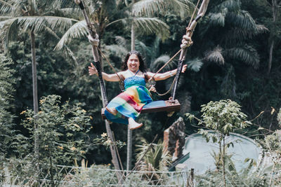 Young pretty asian woman is swinging on the cliff of the jungle in ubud, bali.