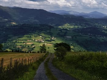 Scenic view of agricultural field by mountains against sky