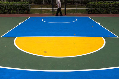 Low section of person walking by basketball court