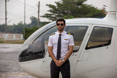 Young man standing by helicopter